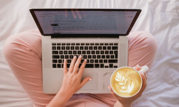 Woman using laptop with coffee