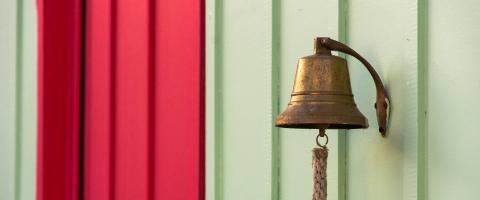 A bell in front of red and white background